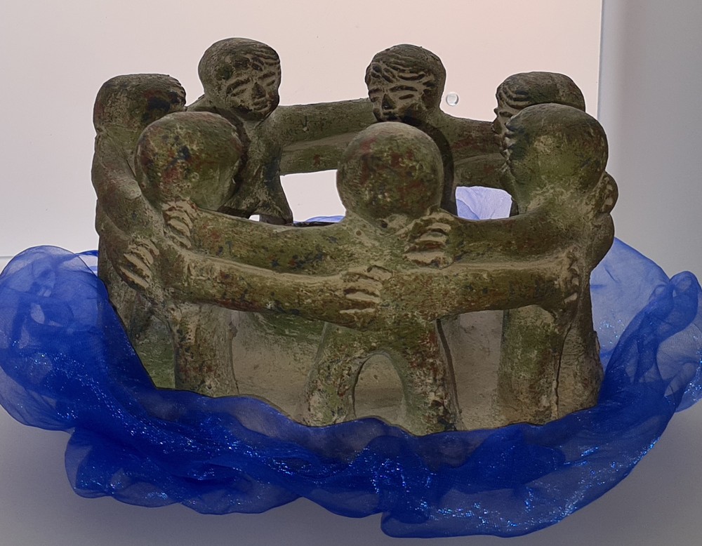 Steinfiguren, die zusammen einen Kreis bilden, darunter ein blaues Tuch