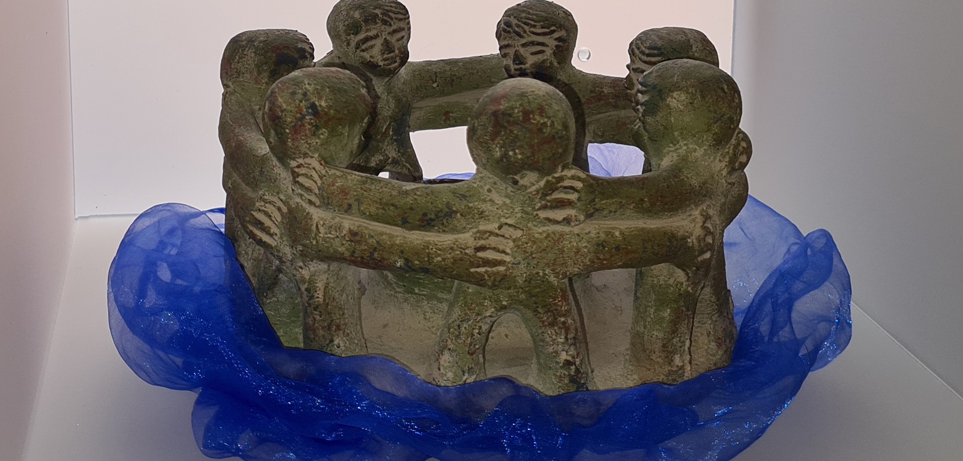 Steinfiguren, die zusammen einen Kreis bilden, darunter ein blaues Tuch