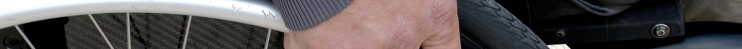 Hand an Handlauf eines Rollstuhls