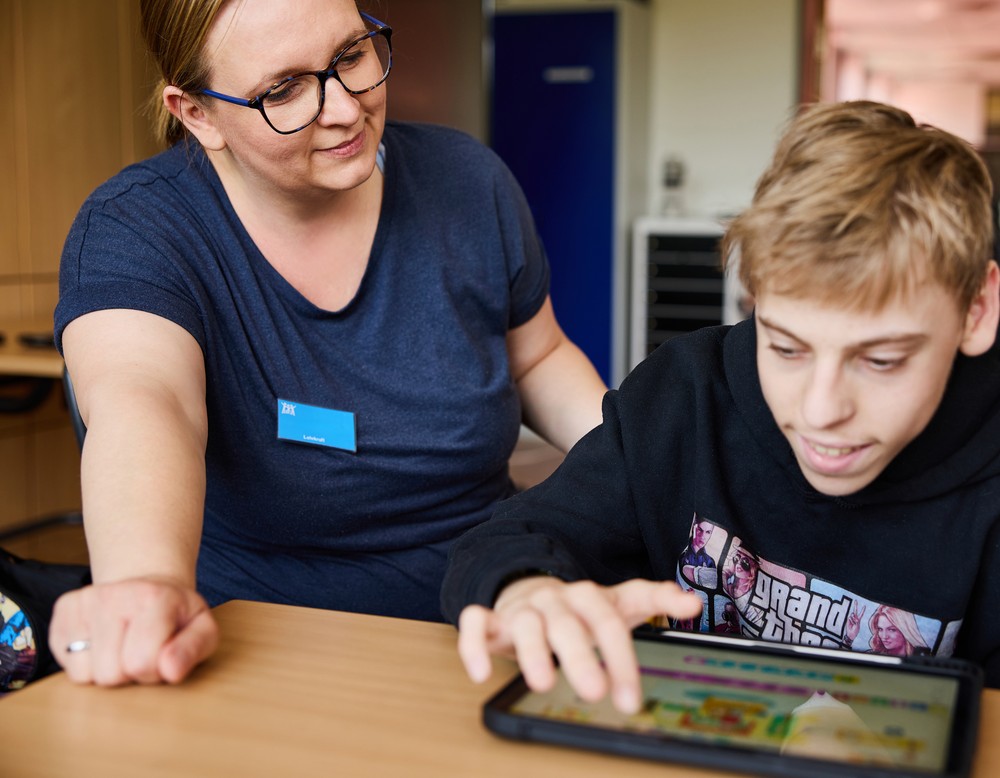 Computer mit Tastatur, Tablet liegt seitlich auf dem Tisch