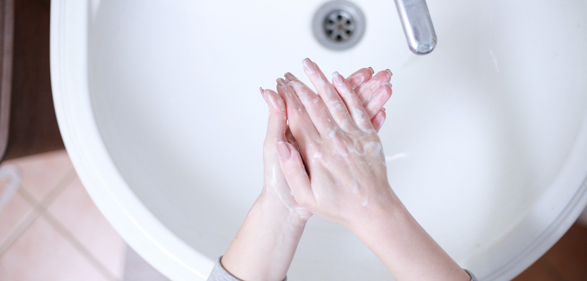 Eingeschäumte Hände über Waschbecken