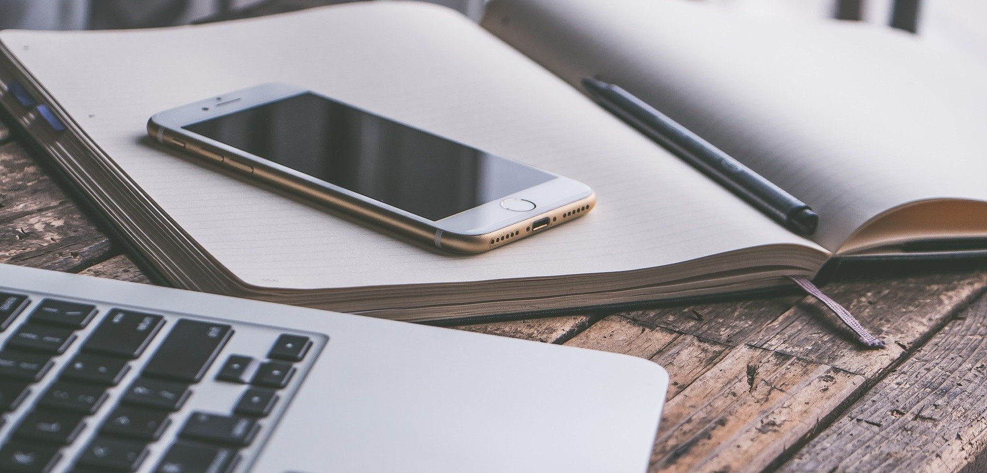 Schreibtisch mit Papier, Laptop und Smartphone