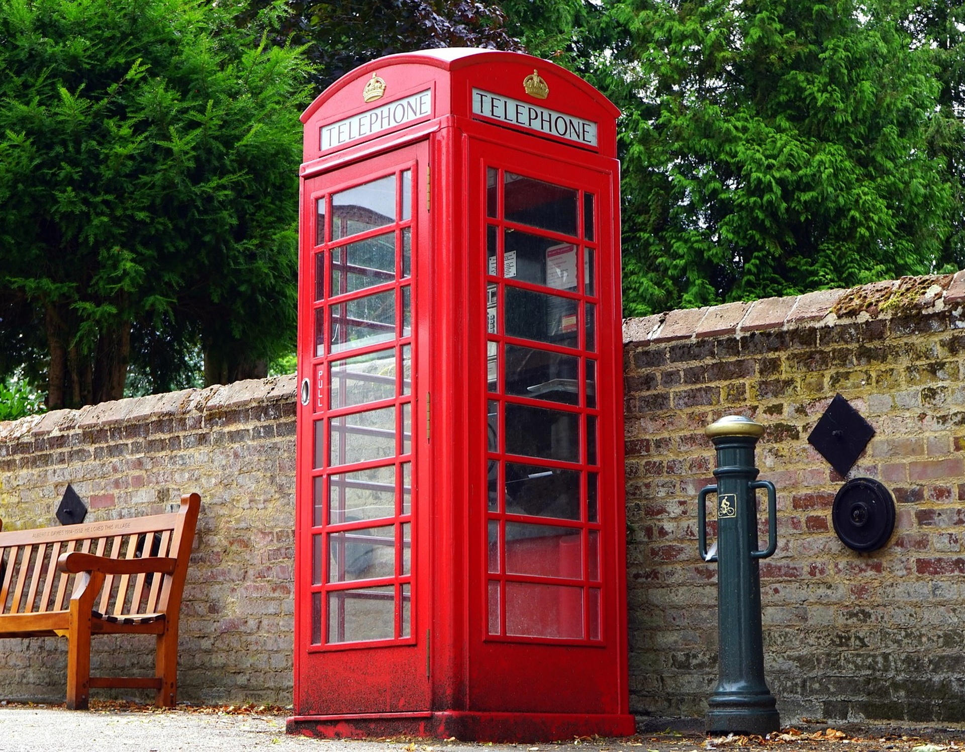 Rote britische Telefonzelle vor Mauer